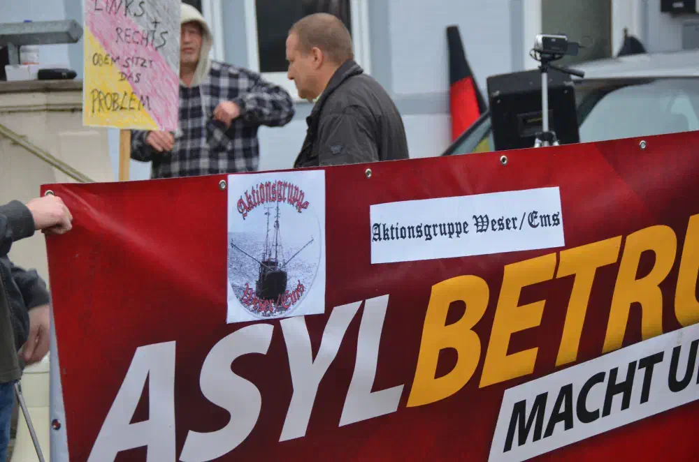 Die "Aktionsgruppe Weser/Ems" verwendet ein Transparent der NPD, das mit eigenen Gruppenlogos beklebt wurde.