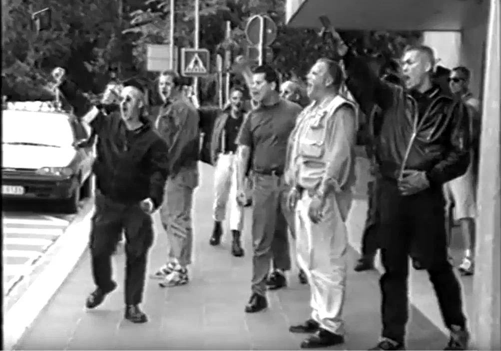 Nachdem 1994 deutschlandweit alle Rudolf Hess Märsche verboten wurden, wichen etliche Neonazis am 13.8. nach Luxemburg aus und randalierten dort vor der deutschen Botschaft. Einer der Beteiligten war der damalige FAP-Funktionär Dieter Riefling (links im Bild)