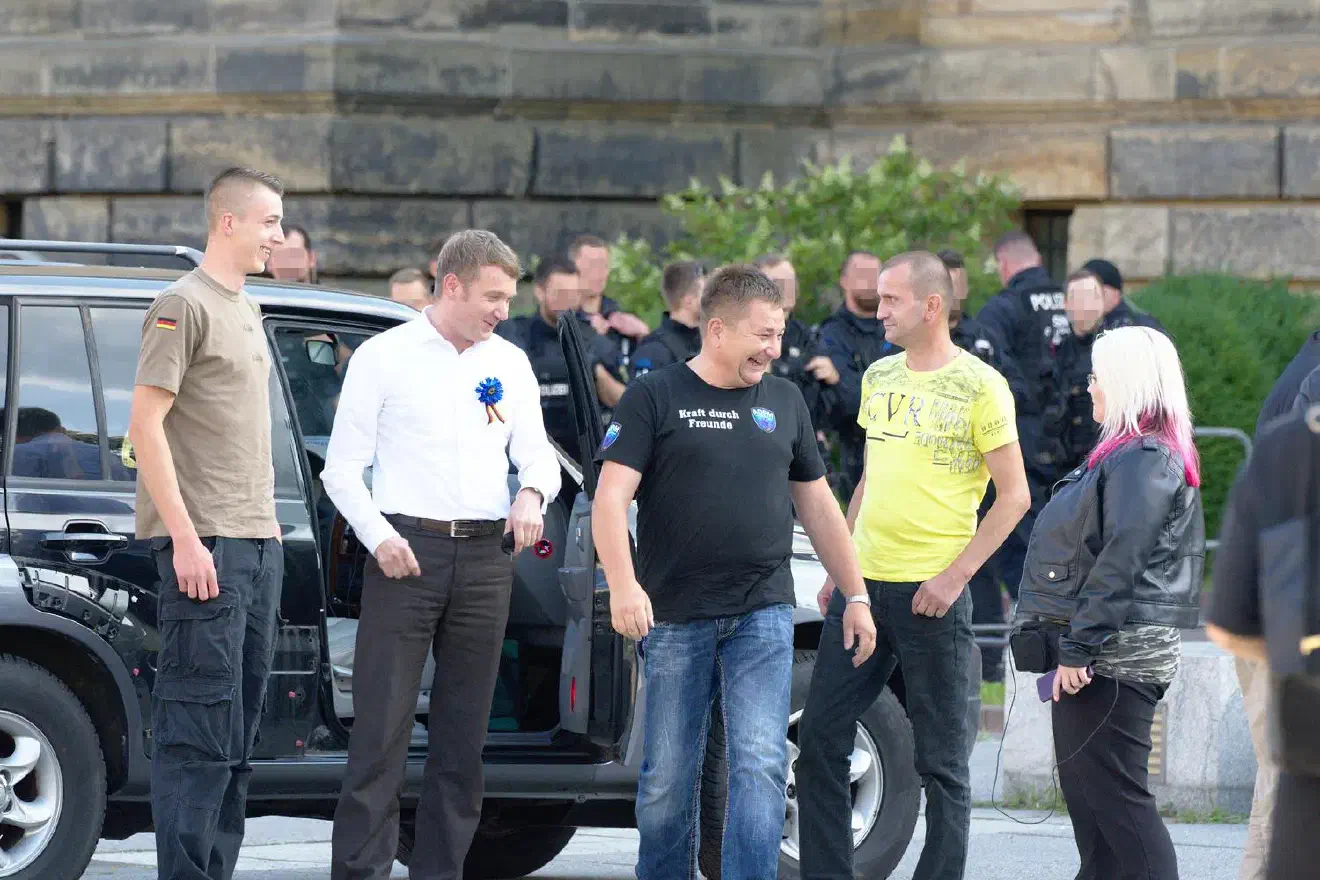 Egbert Ermer trug wie hier zu sehen ein T-Shirt mit der Aufschrift »Kraft durch Freunde«, was als Anspielung auf die nationalsozialistische Freizeitorganisation »Kraft durch Freude« (KdF) verstanden werden darf.