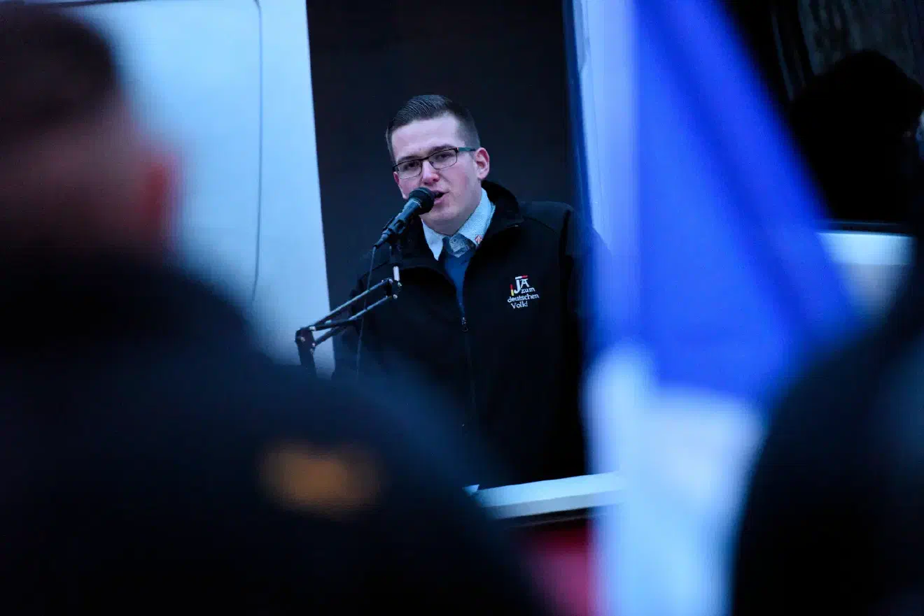 Erster Redner der Kundgebung am Funkhaus war Sebastian Weigler. Weigler war in seiner Rede sichtlich bemüht alle vorher angekündigten Demonstrationsthemen abzuarbeiten, ohne dabei in den Fokus polizeilicher Ermittlungen zu geraten. Ein Vorhaben, das bei den Teilnehmer*innen nur für müden Applaus sorgte.