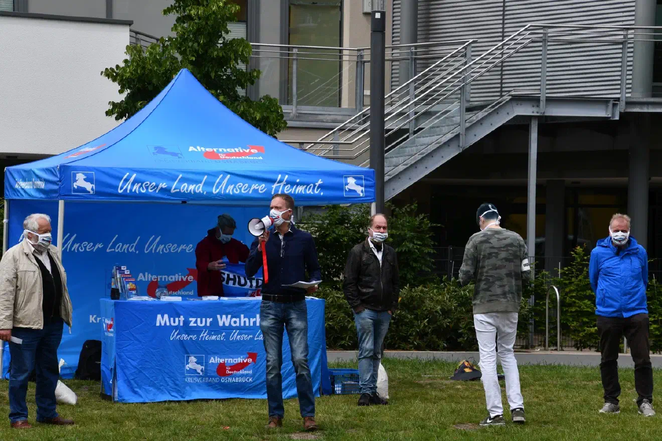 Als Versammlungsleiter und erster Redner trat der Kreisvorsitzende Florian Meyer (Bildmitte) auf. Das kleine Megafon war aber wegen der lauten Gegenproteste kaum wahrnehmbar und so gingen die Redebeiträge sämtlicher Redner im Lärm der Gegenproteste unter.