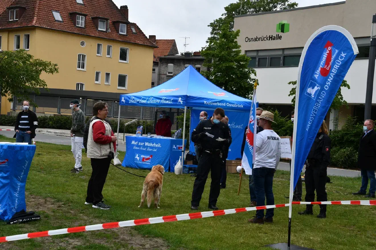 Der Redebeitrag von Herrn Meyer musste zwischenzeitlich unterbrochen werden, weil zwei Teilnehmer keinen Mund-Nasenschutz getragen haben. Nach Kontrolle der ärztlichen Bescheinigungen durfte die Kundgebung fortgesetzt werden.