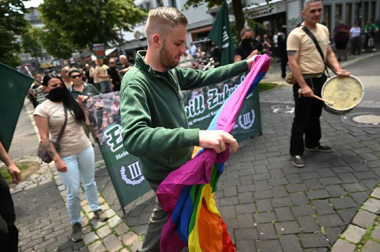 Als besondere Aktion zerrissen Parteianhänger*innen vor dem Start der Demonstration eine Regenbogenflagge.