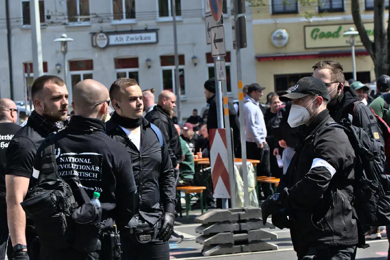 Deren Mitglieder treten regelmäßig in Einheitskleidung und Quarzhandschuhen in Erscheinung.