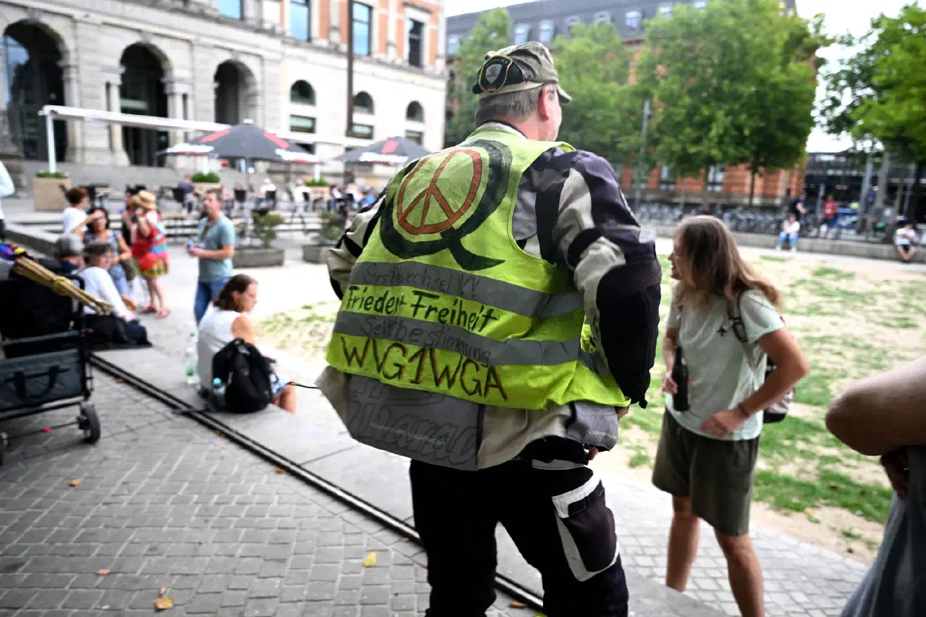 Teilnehmer mit künstlerisch wertvoll gestalteter Q-Anon-Warnweste.