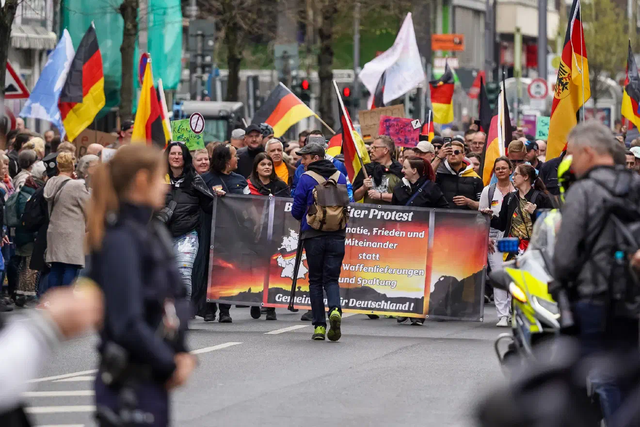 Ein Autokorso mit rund 20 Fahrzeugen, geschmückt mit Deutschlandfahnen und politischen Botschaften, setzte sich von der Düsseldorfer Messe in Richtung Innenstadt in Bewegung. Viele der Parolen erinnerten an frühere Proteste aus dem Kreis der Maßnahmenkritiker:innen.