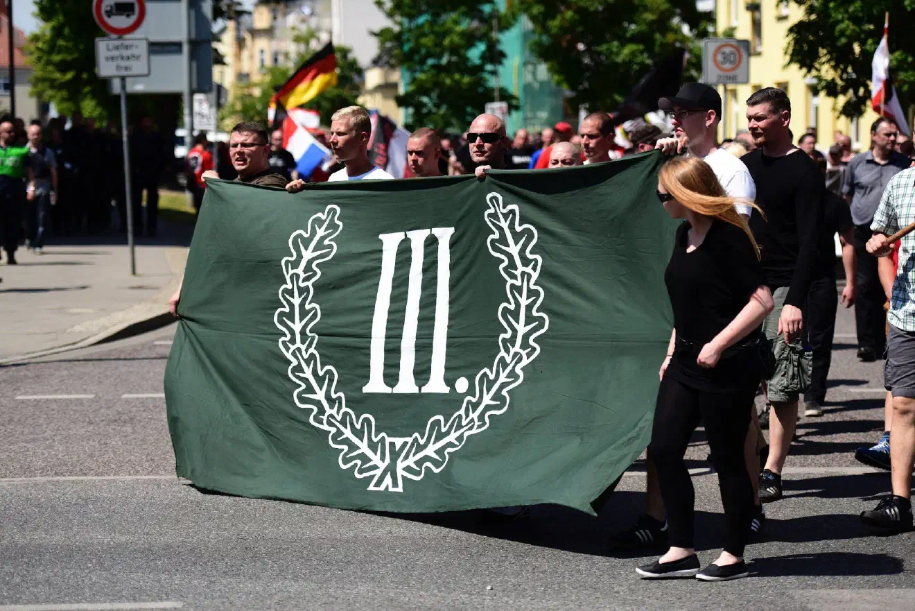 Eine diesbezügliche Konkurrenz wird auch zur Partei „Dritter Weg“ aufgemacht. Dies vor allem, seitdem der „Dritte Weg“ zunehmend von seiner elitären Einstellung abweicht, die in der Vergangenheit für viele Neonazis eine große Hürde bzgl. einer potenziellen Mitgliedschaft darstellte. Mit der zunehmenden Aufweichung dieser Barrieren wird die Partei zumindest im Bezug auf eine potenzielle Mitgliedschaft von interessierten Neonazis eine größere Konkurrenz für die NPD. Dies zeigt auch ein Blick auf die Teilnehmer:innen der Demonstration des „Dritten Weges“ am 01. Mai 2022 in Zwickau.