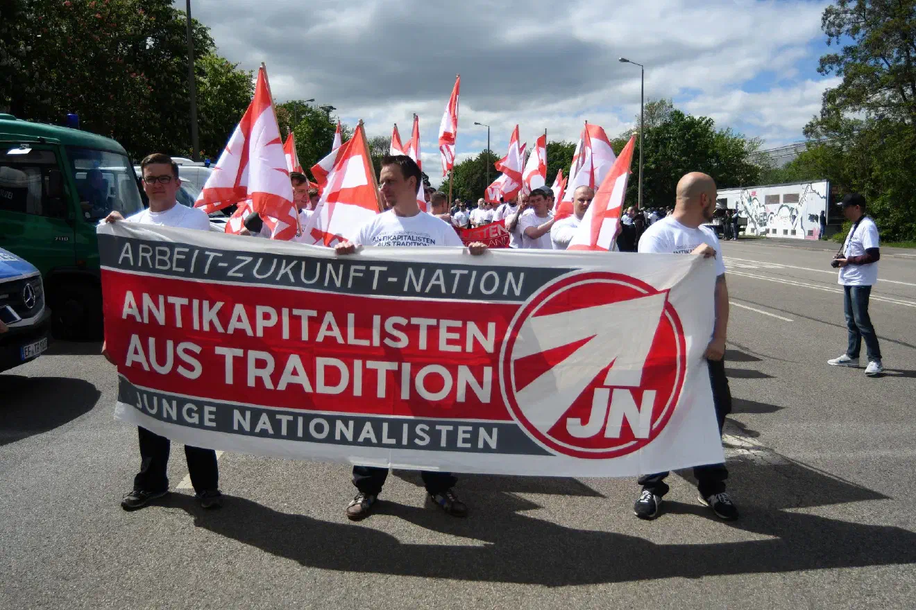 Die Richtungsentscheidung auf dem NPD Bundesparteitags wird auch von der JN, der NPD-Jugendorganisation um ihren Bundesvorsitzenden Sebastian Weigler (links im Bild), mit Spannung erwartet. Im April diesen Jahres drohte die JN bereits mit Lossagung von der als „schwarzes Loch“ bezeichneten Mutterpartei und regte die Auflösung der NPD an, falls keine grundlegende Neuaufstellung vollzogen wird.